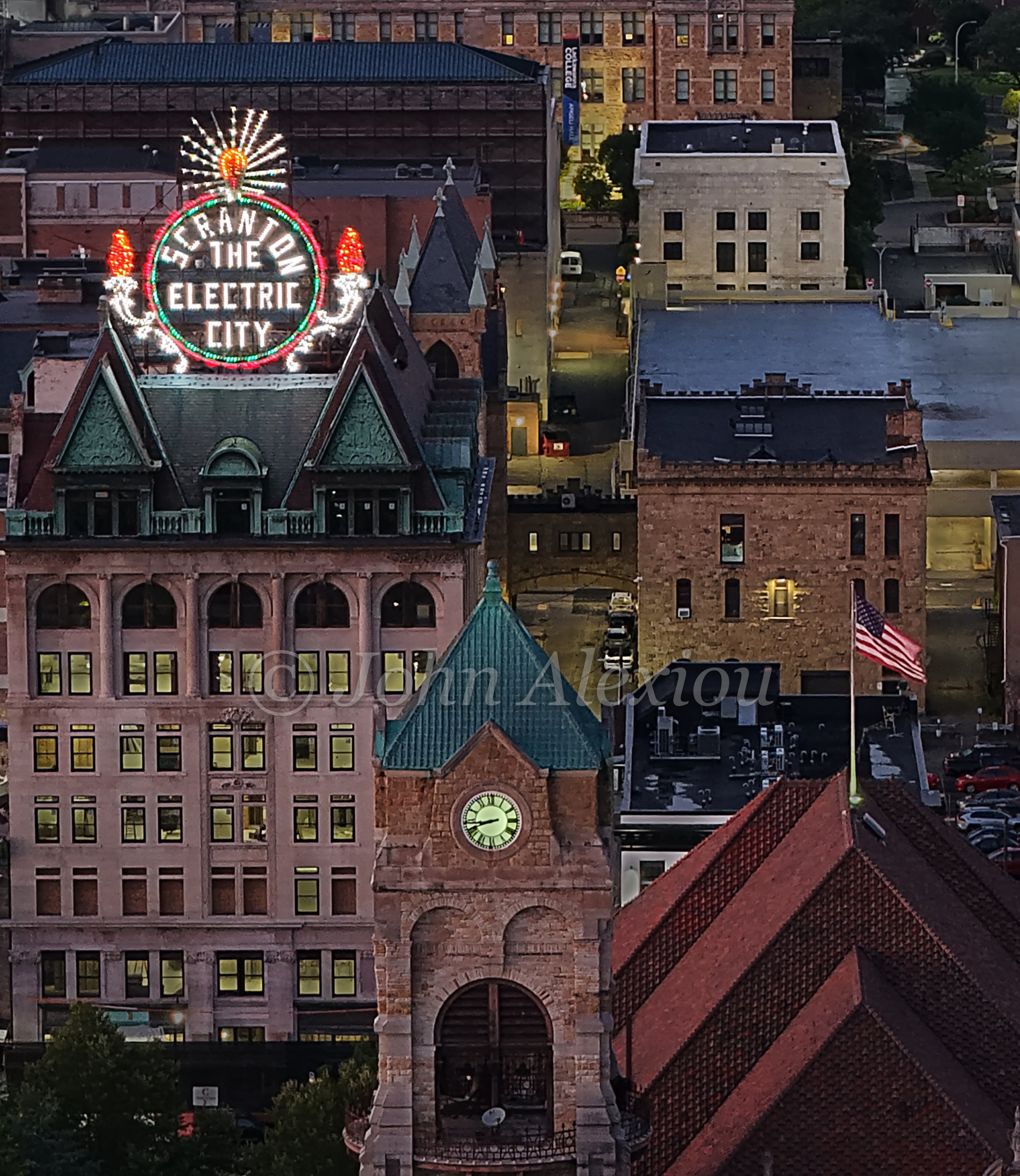01 · The City Lights Up
The Electric City sign glows above green rooftops and a clock tower as evening settles over Scranton.
© John Alexiou · 2025 · Electric City, Scranton