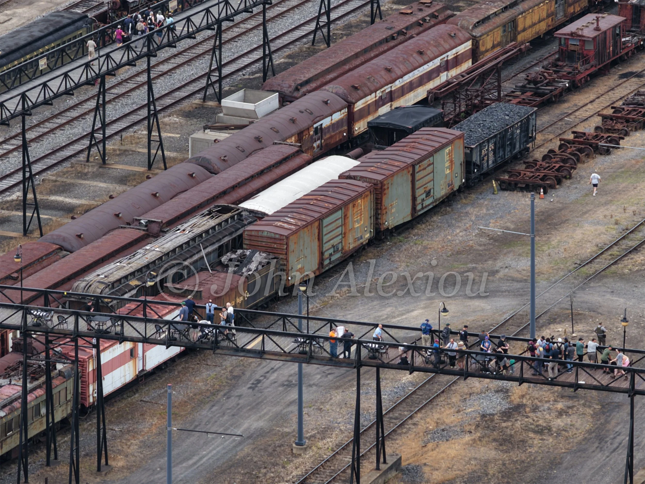 06 · Across the Yard
Visitors cross the elevated walkway above rows of weathered passenger cars and freight cars at Steamtown.
© John Alexiou · 2026 · Steamtown, Scranton