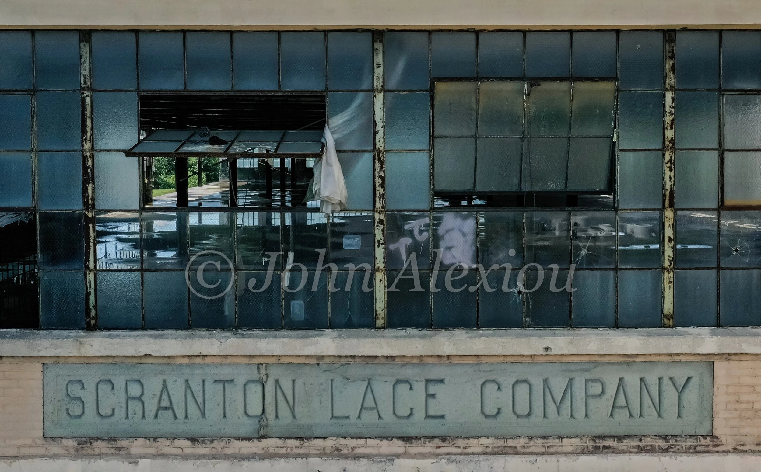 01 · The Name Still Stands
The Scranton Lace Company name remains beneath a row of damaged factory windows.
© John Alexiou · 2019 · Scranton Lace Company