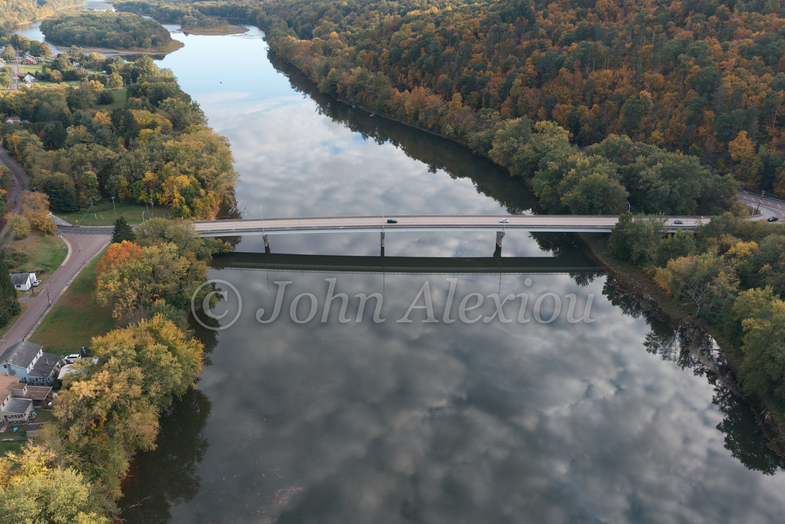 06 · Bridge Over Reflected Clouds
A bridge crosses the river above reflected clouds, joining two banks edged with autumn trees.
© John Alexiou · 2026 · Susquehanna Valley
Hasselblad L3D-100c · 14.4 mm · f/2.8 · 1/320 s · ISO 200