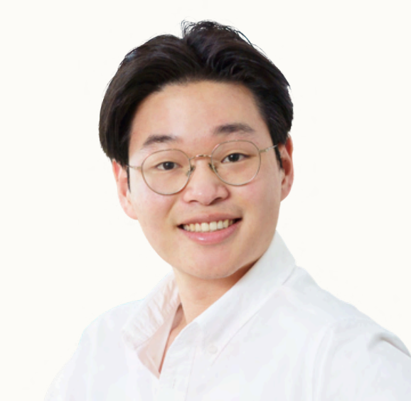 Young man wearing glasses and a white shirt smiling at the camera against a plain white background.