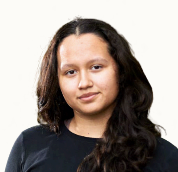 Young woman with long dark wavy hair wearing a black shirt, looking at the camera against a plain light background.