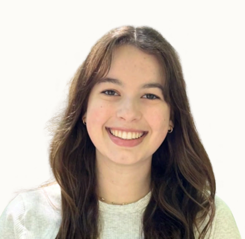 A young woman with long brown hair smiling in front of a white background.