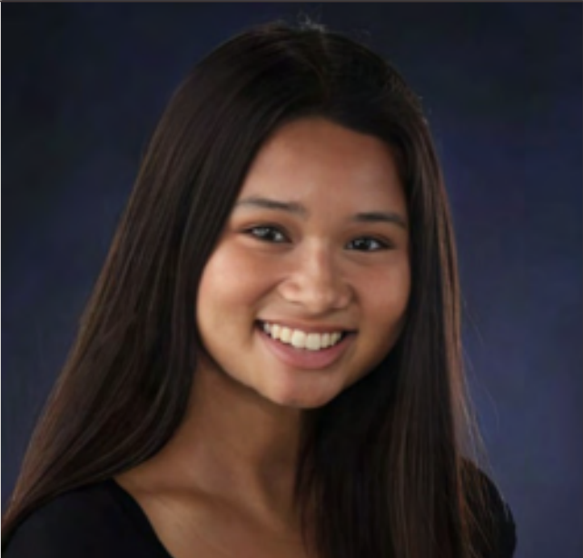 A young woman with long dark hair smiling at the camera against a dark blue background.