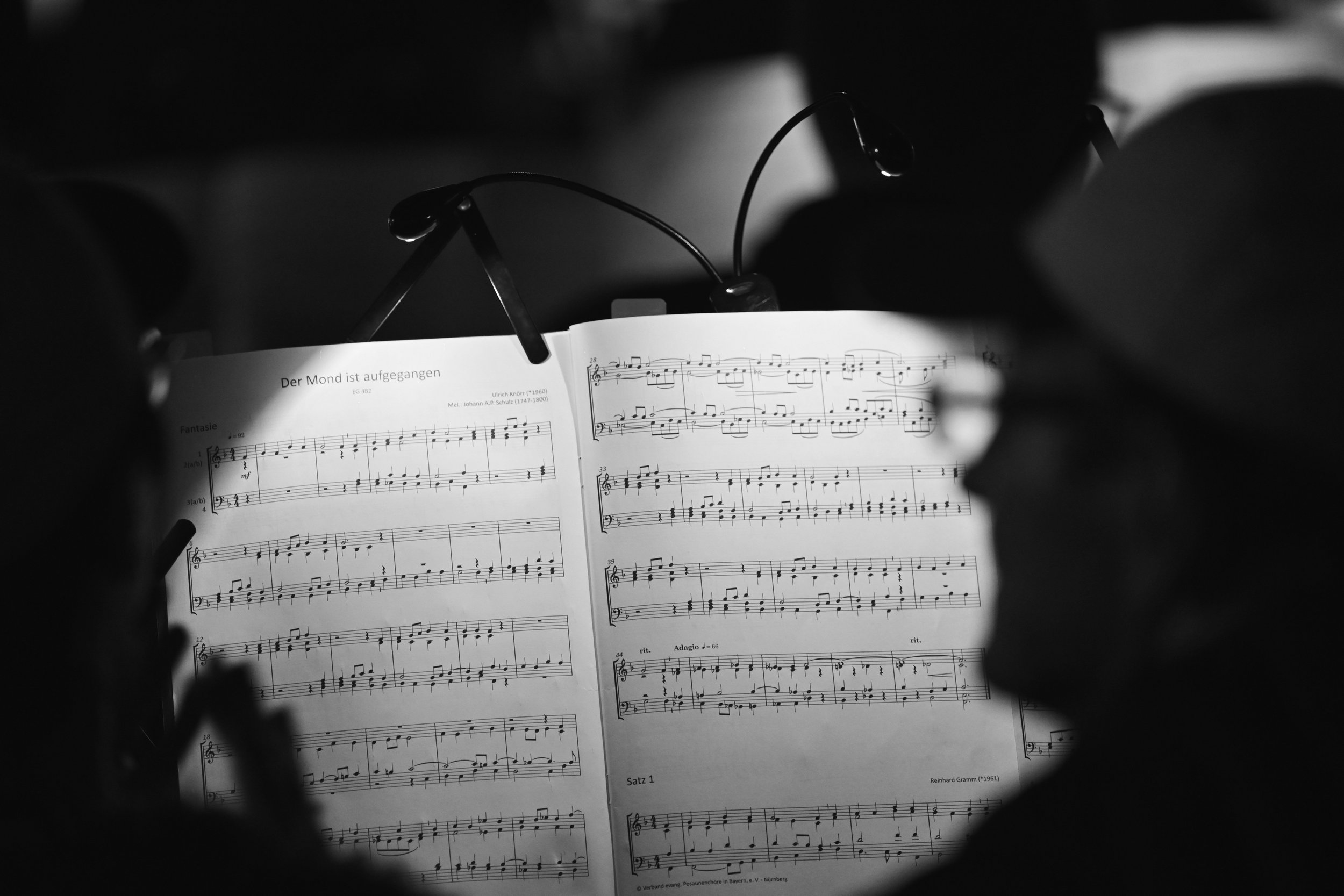 Person reading sheet music titled 'Der Mond ist aufgegangen'.