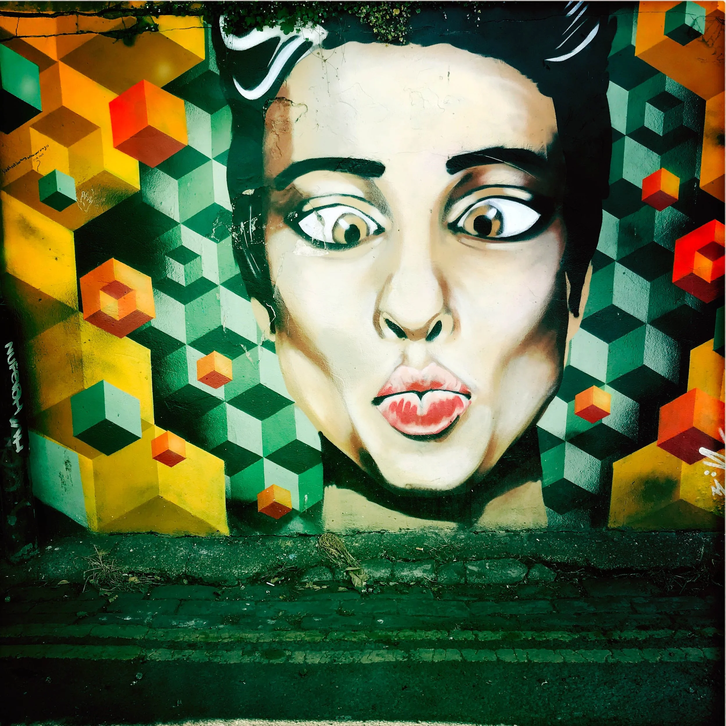 Street art in Brighton.Woman's face with a cube background.