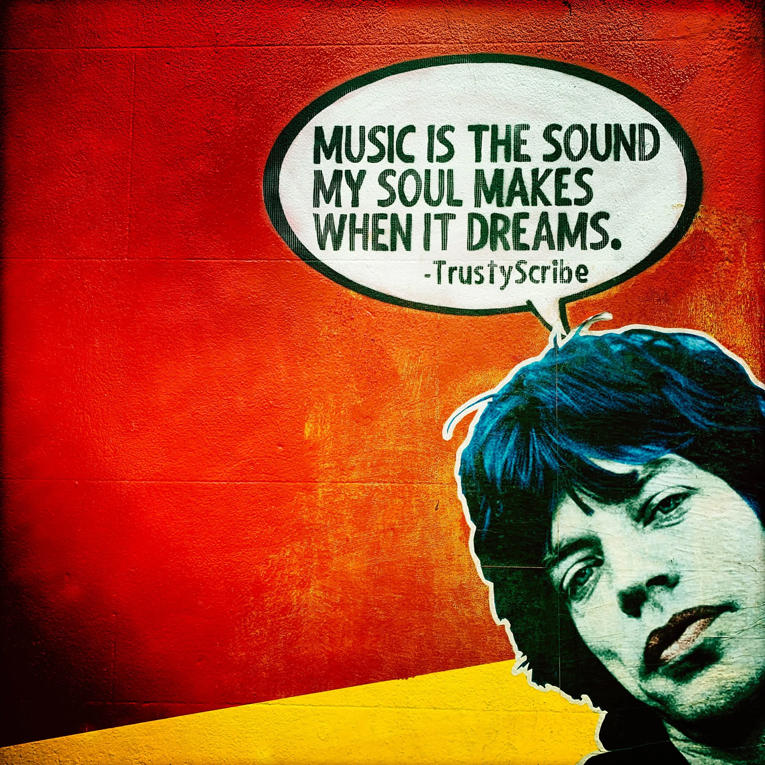 Street art. Mick Jagger with red and yellow background in Brighton. Music is the sound my soul makes when it dreams