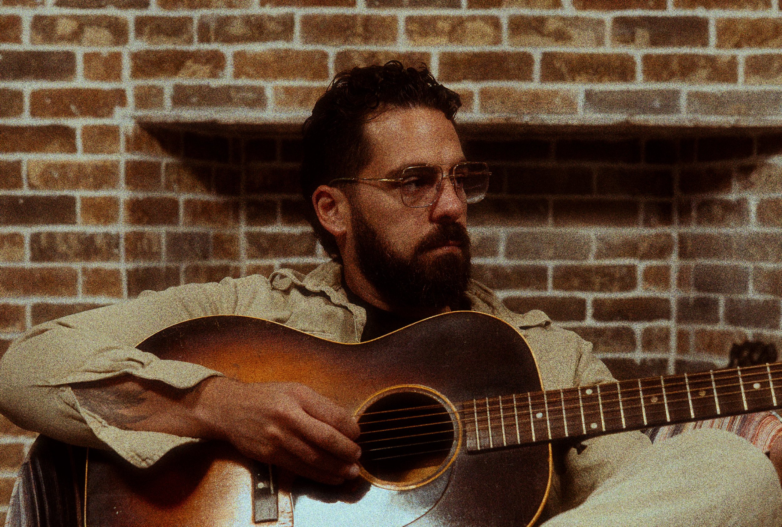 Omer Netzer sitting with his guitar
