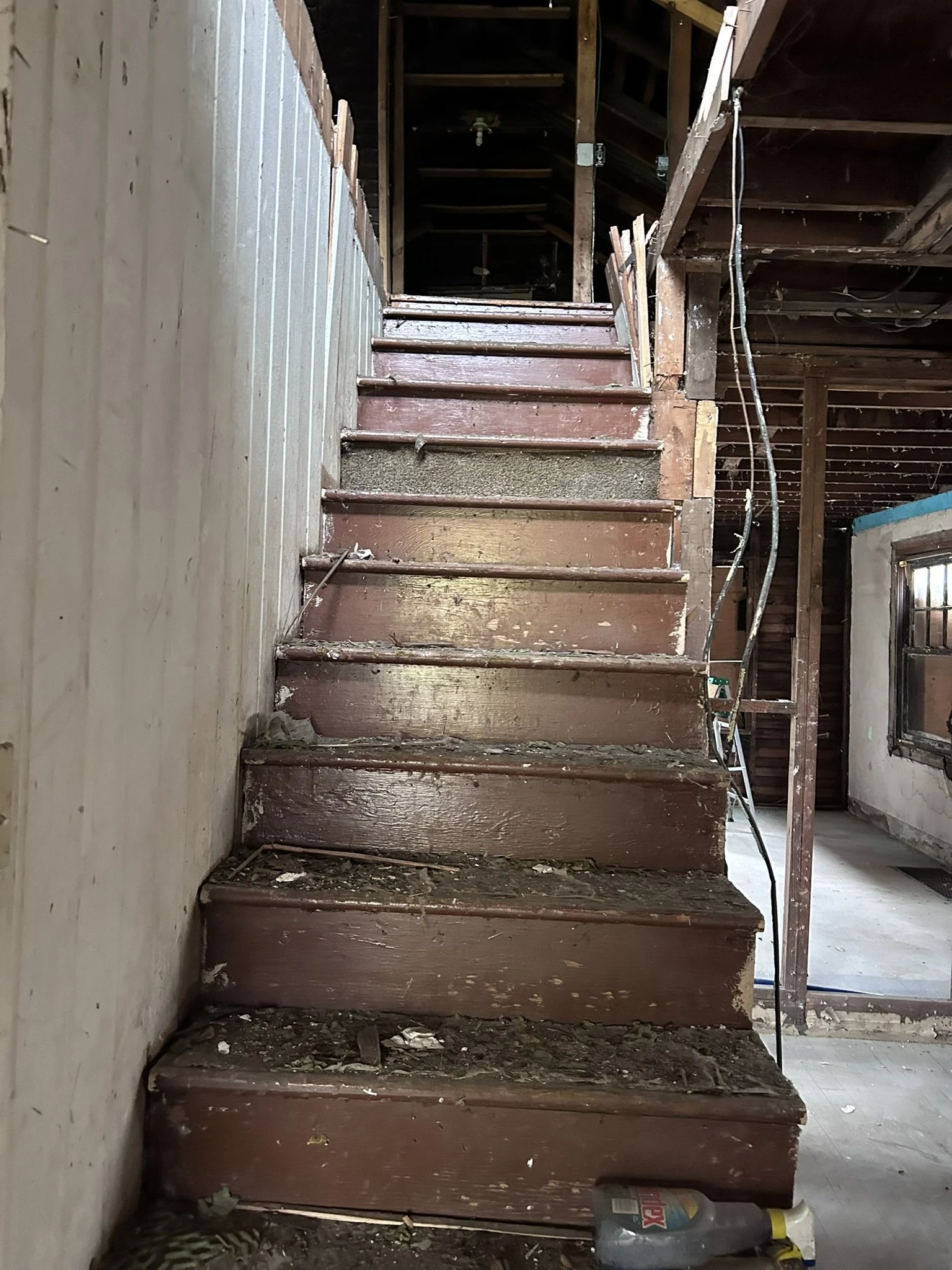 Unfinished and dirty wooden staircase in a house under renovation.