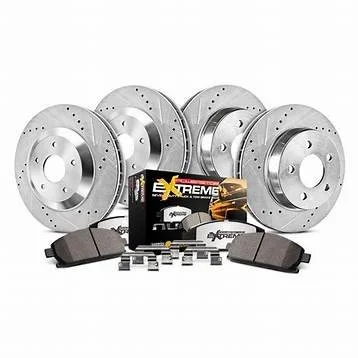 Set of four silver brake rotors with black brake pads, brake hardware, and brake pad clips, along with a box of brake parts in the center.