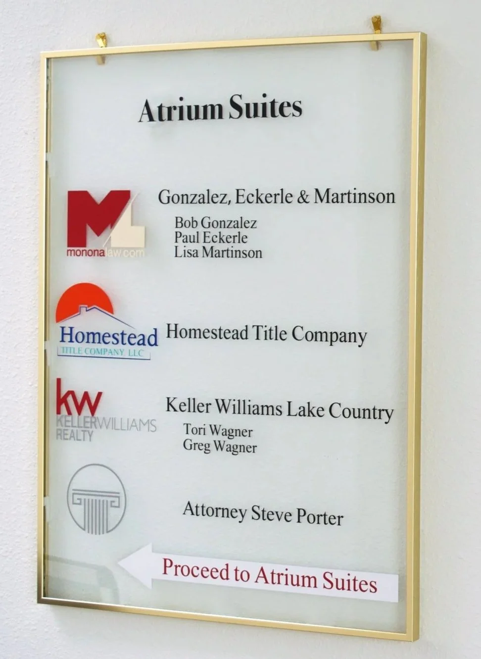 Signboard listing attorneys and real estate companies at Atrium Suites, with directional arrow pointing left for proceeding to Atrium Suites.