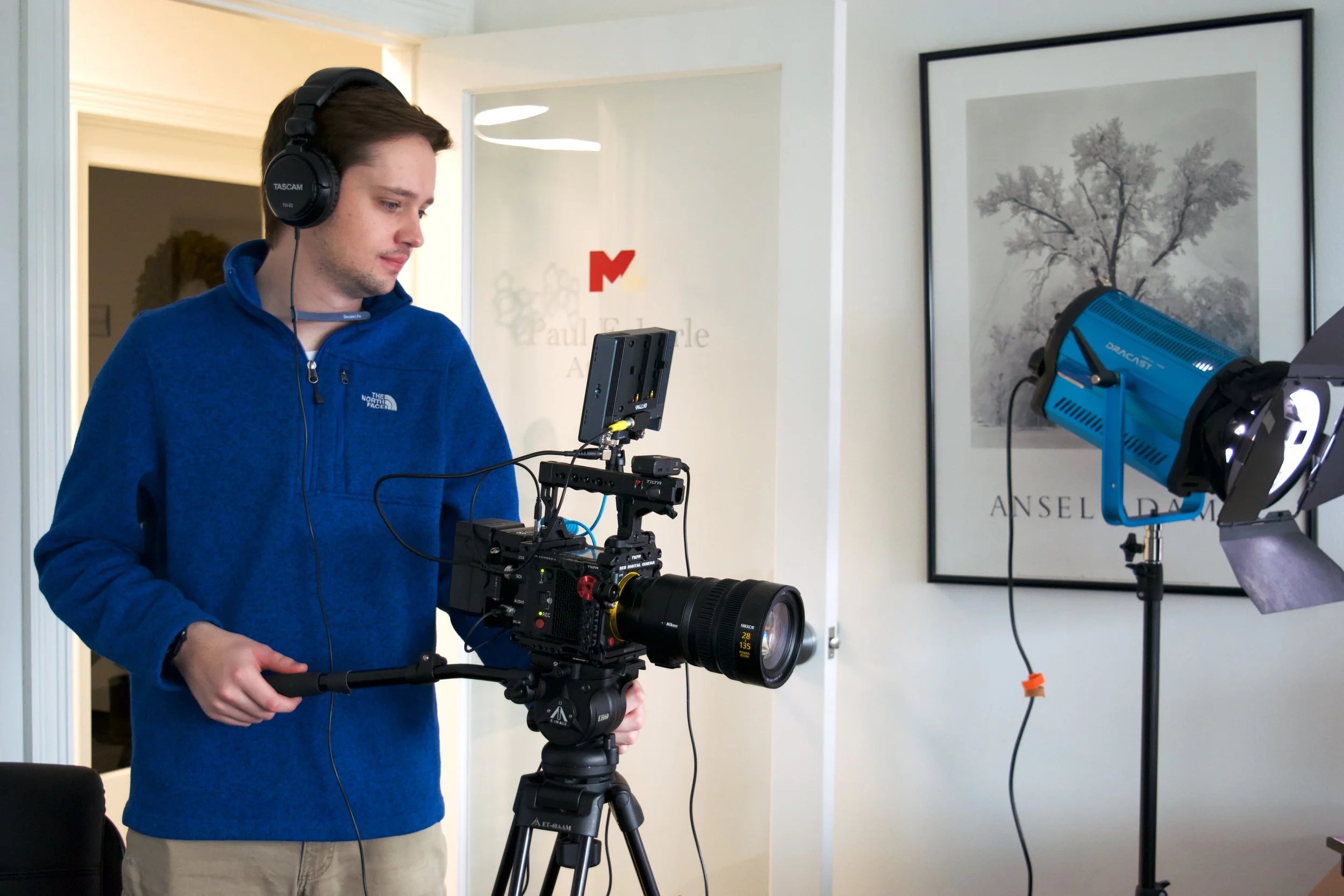 Founder of 1101 Video, LLC operating RED Komodo X cinema camera on tripod in indoor studio environment.