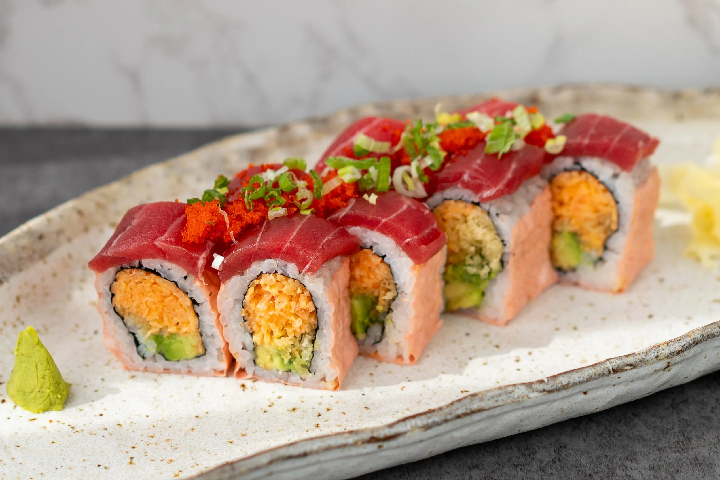 Special roll with shredded crab and kani, avocado, crunch, wrapped in nori, sushi rice, soy paper, and topped with maguro tuna, scallions, and tobiko.