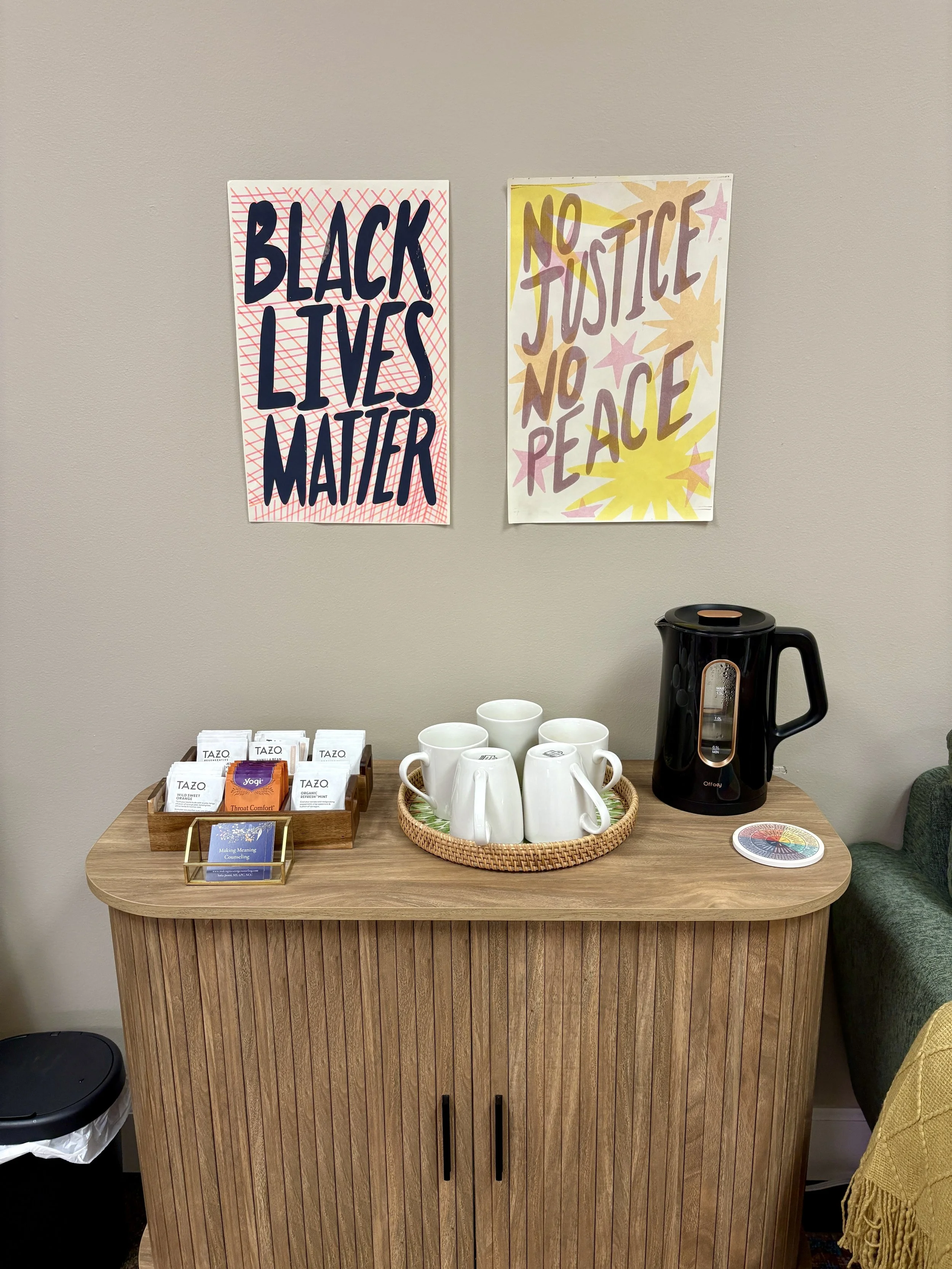 A photo showing mugs and teas available when meeting for counseling and therapy at Laughing Fox Counseling with Fletcher Marron. Art on the walls proudly states Black Live Matter and No Justice, No Peace.