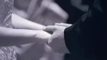 Close-up of a couple holding hands during a wedding ceremony. Couples counseling and therapy is offered at the Healing Hollow.