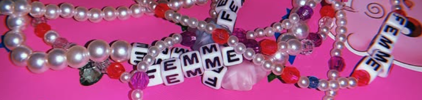 Array of colorful beaded necklaces and bracelets, including pearl and letter beads spelling 'FEMALE' on a pink background.