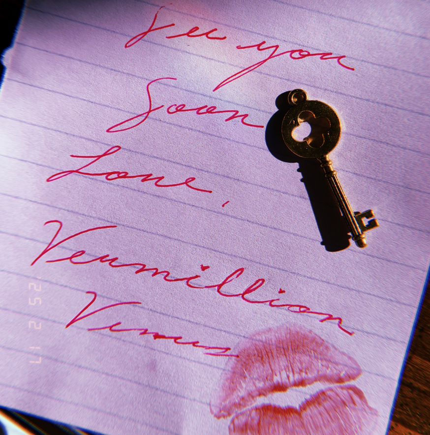 A lined notebook page with handwritten red ink writing, a gold vintage key, and a pink lipstick kiss mark.