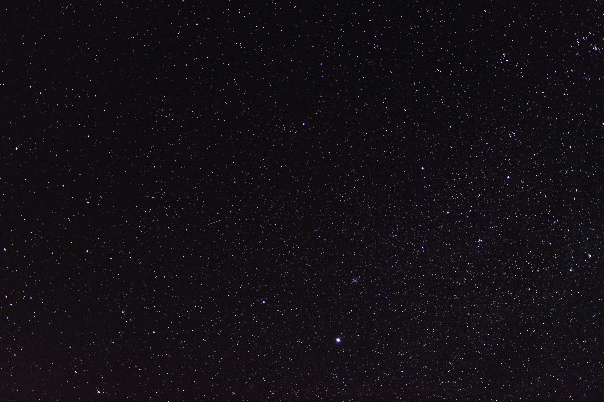 Starry night sky with numerous stars scattered across a dark background.