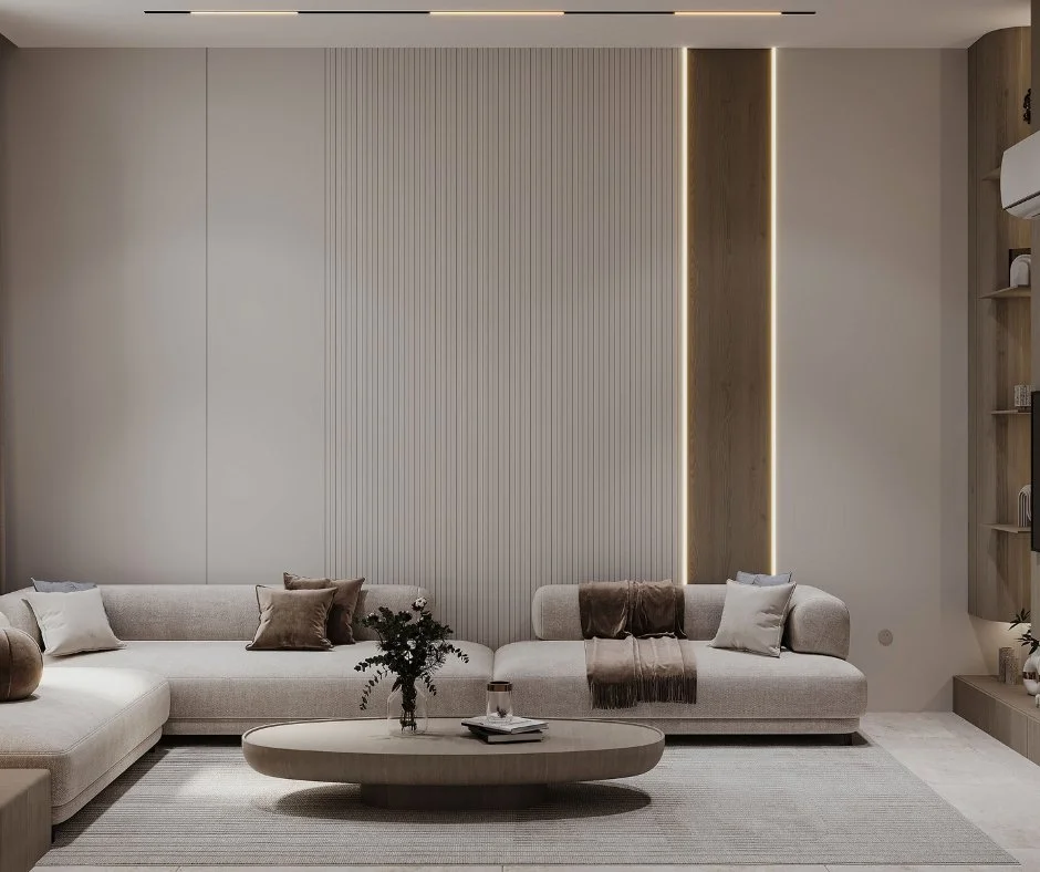 Sala de estar moderna con sofá beige, mesa de centro ovalada, alfombra clara y paredes decorativas con iluminación sutil.