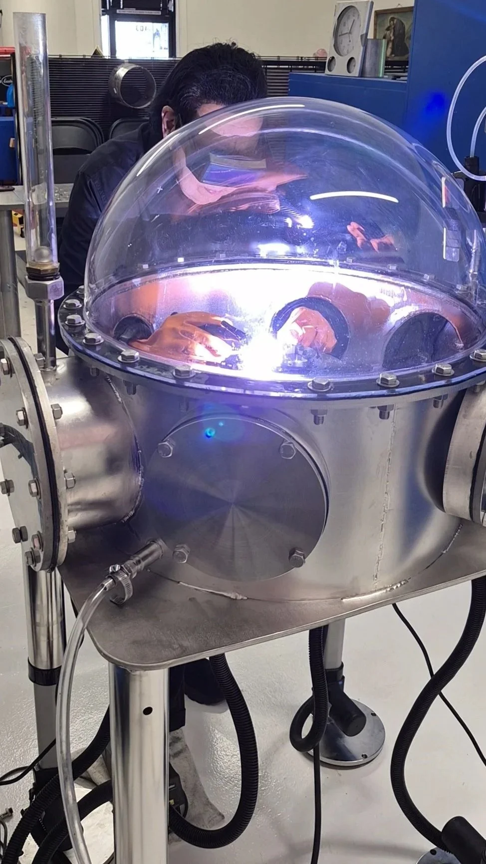 Operator at TRON E-24 with UV-protective dome and arc visible — Spacetron Valencia CA facility