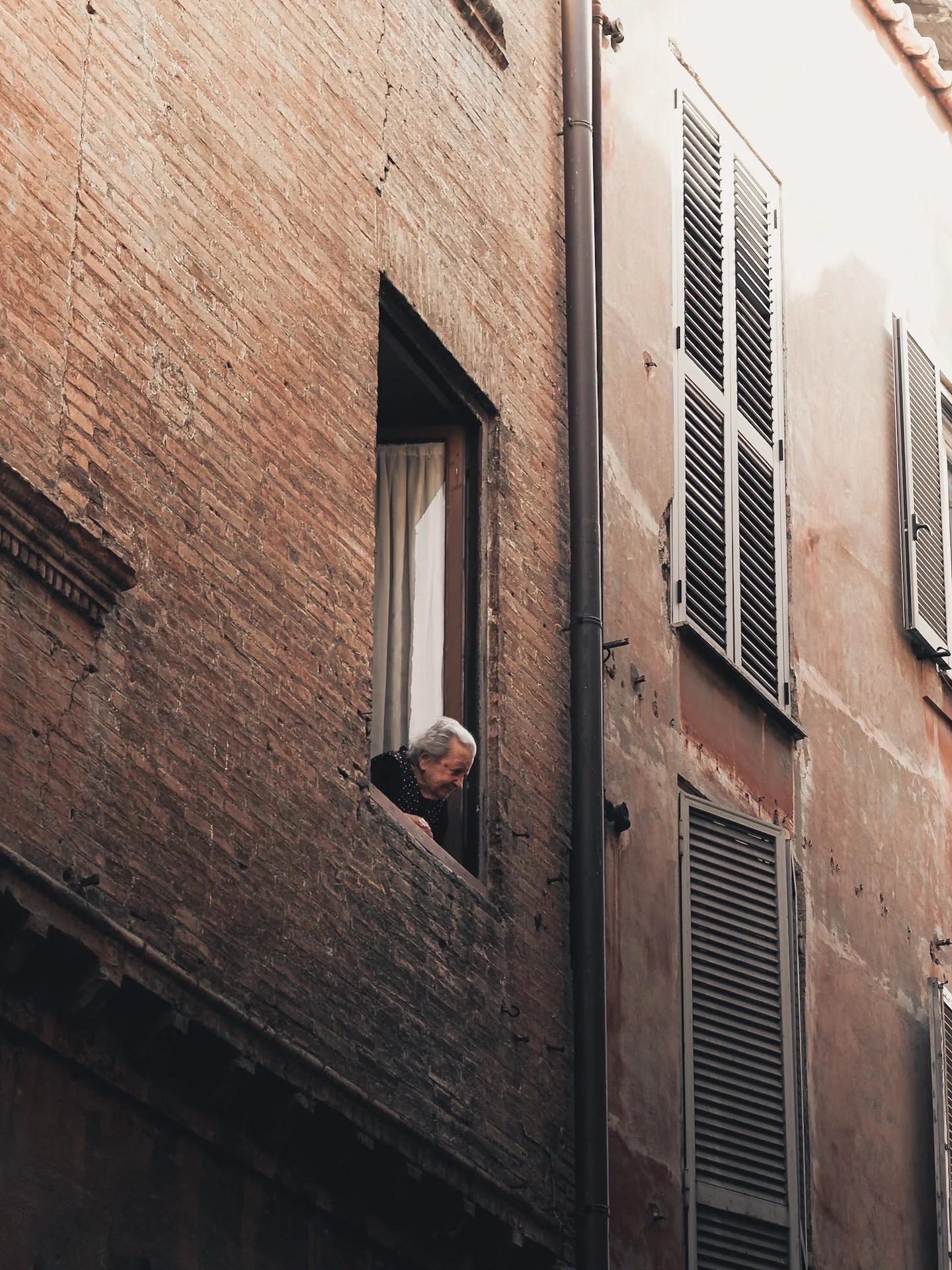 Everyone talks about Rome&rsquo;s chaos &mdash; the scooters, the crowds, the noise &mdash; but what I found most beautiful were the quiet moments in between.
A man smoking a cigarette at a tiny bar. A woman leaning out her window to see who&rsquo;s 