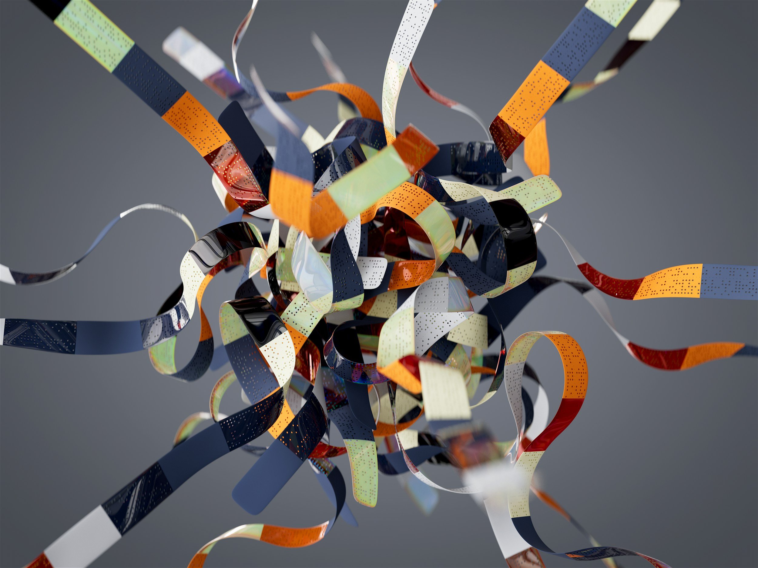 Colorful curling ribbons in black, orange, yellow, red, green, and white, floating against a plain gray background.
