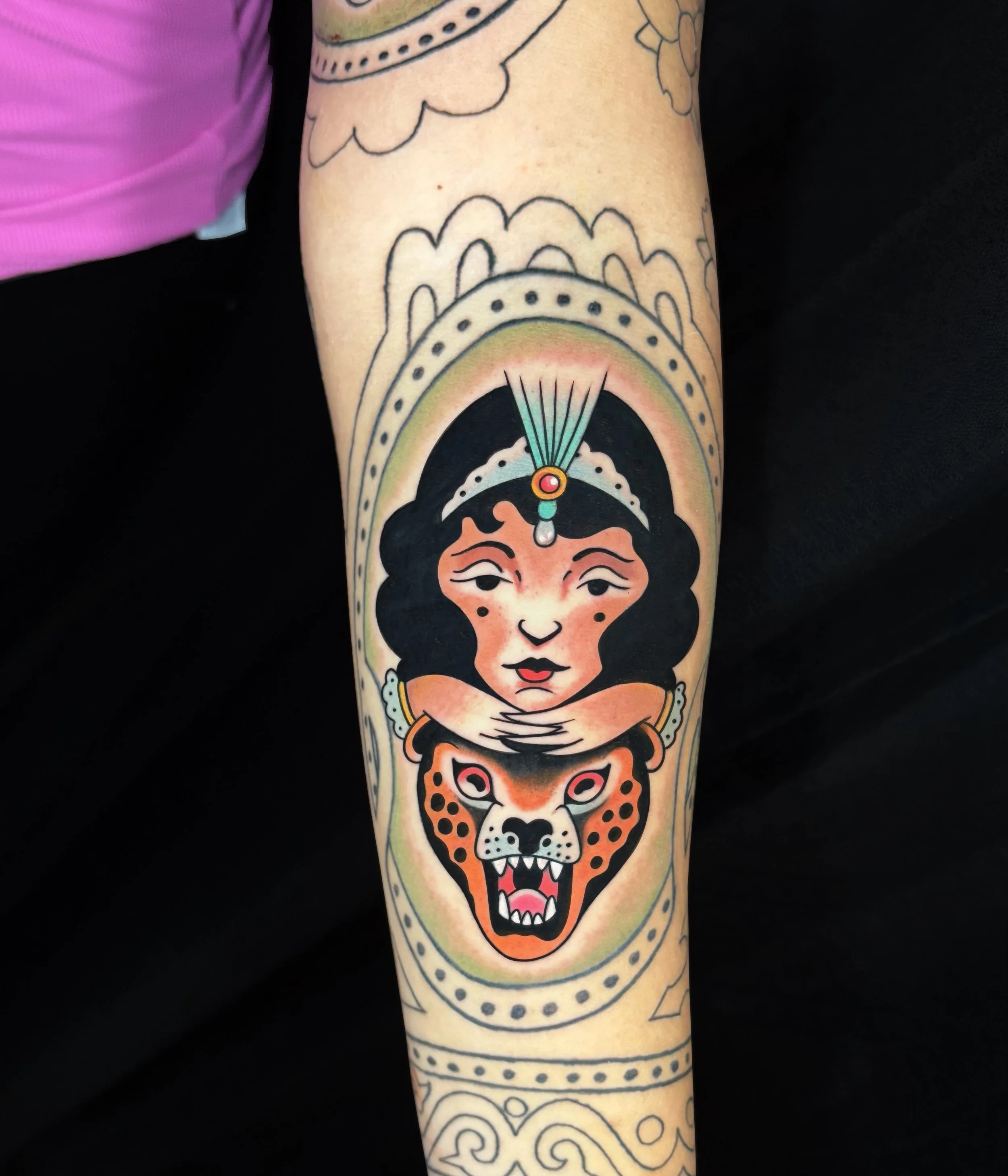 American Traditional tattoo of a woman with a jaguar headdress on the forearm, bold colors and clean lines, done by Flow Kappa in West Palm Beach Florida.