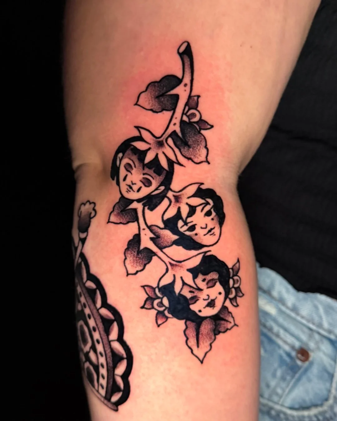 American traditional strawberry tattoo done in West Palm Beach, Florida. This custom tattoo features multiple strawberries with feminine faces, designed with bold outlines, strong contrast, and a classic American traditional aesthetic. Tattooed by Fl