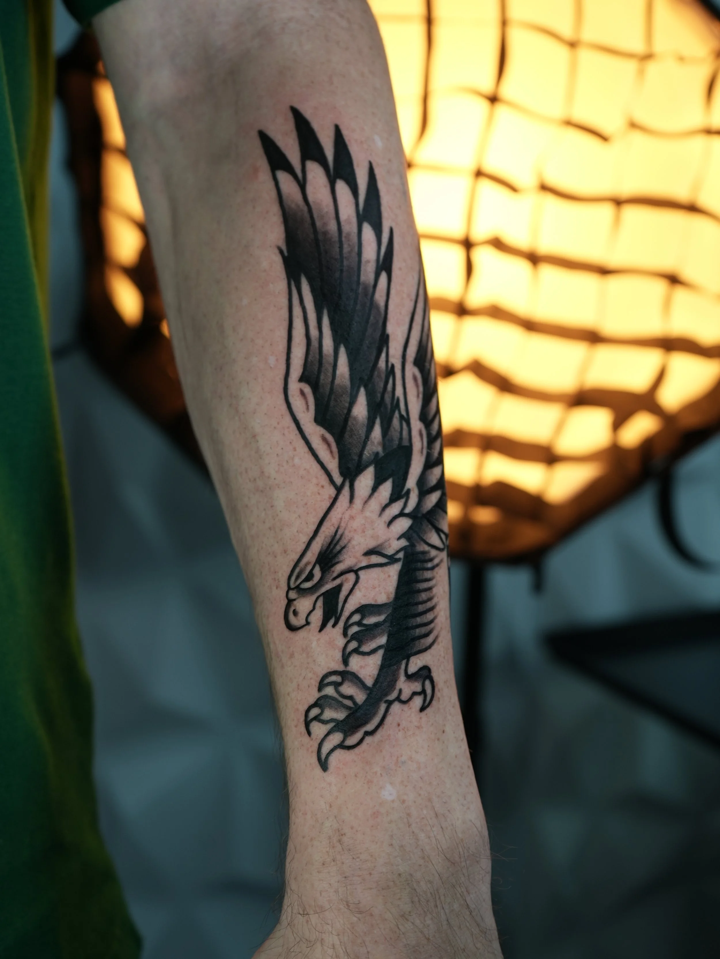 American Traditional eagle tattoo on forearm by Flow Kappa Tattoo in West Palm Beach, Florida. Bold black ink tattoo featuring a classic eagle design.