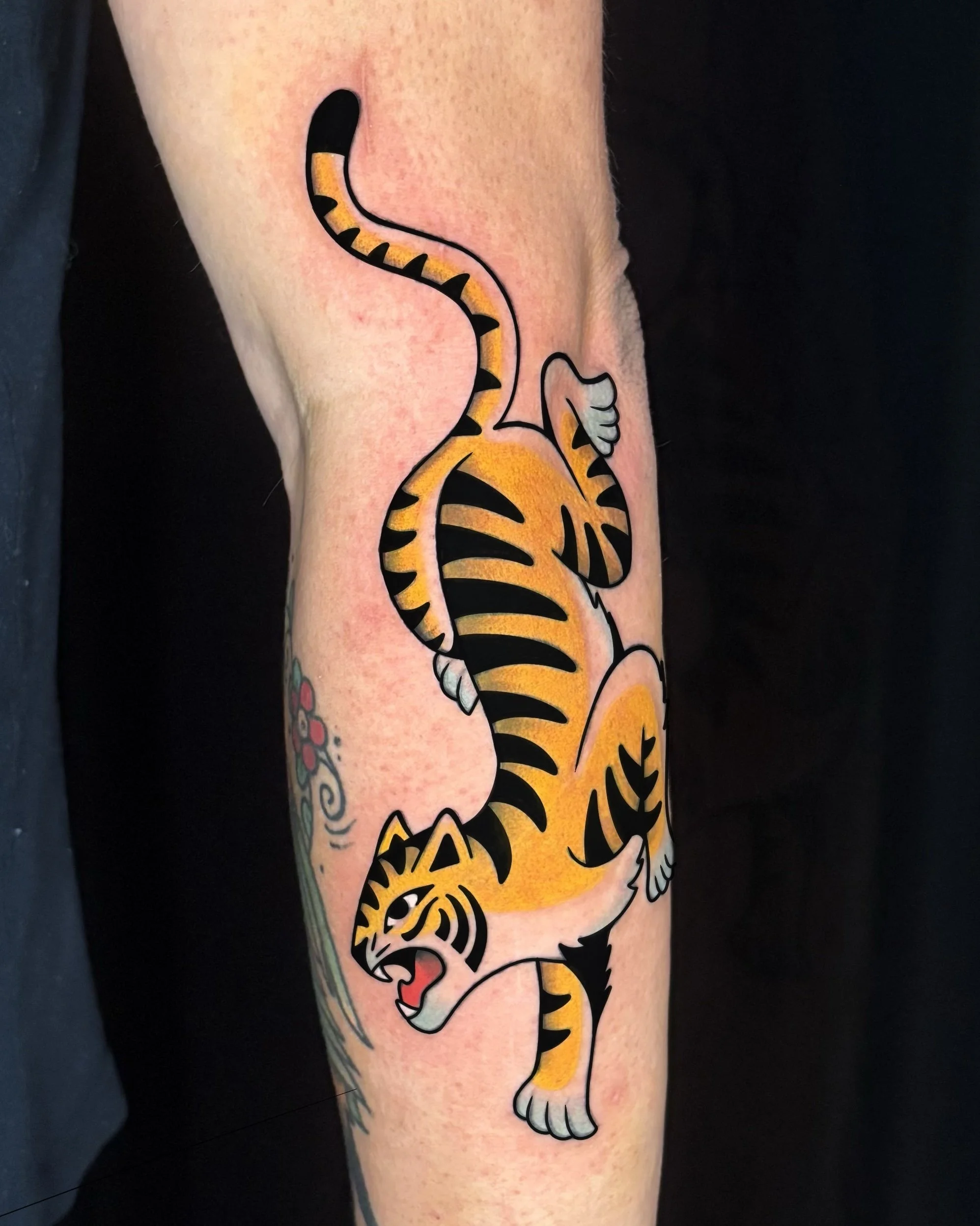 American traditional tiger tattoo featuring bold colors, strong black linework, and dynamic movement. Custom tattoo by Yonathan Suarez, a traditional and illustrative tattoo artist in West Palm Beach, Florida.
