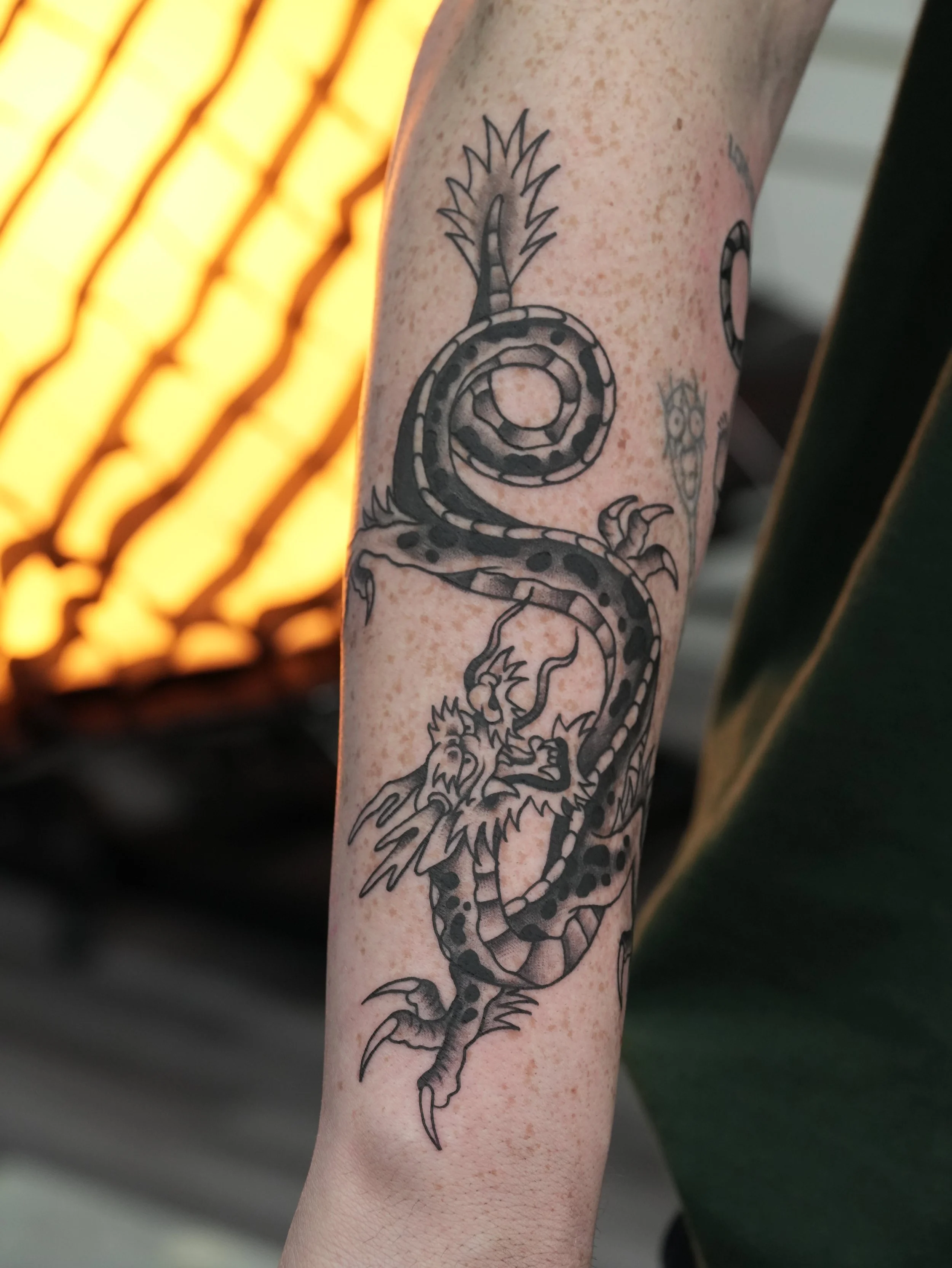 Custom traditional Japanese dragon tattoo in black and grey, featuring bold linework, flowing movement, and detailed scales. Tattooed by Yonathan Suarez, a traditional and illustrative tattoo artist in West Palm Beach, Florida.