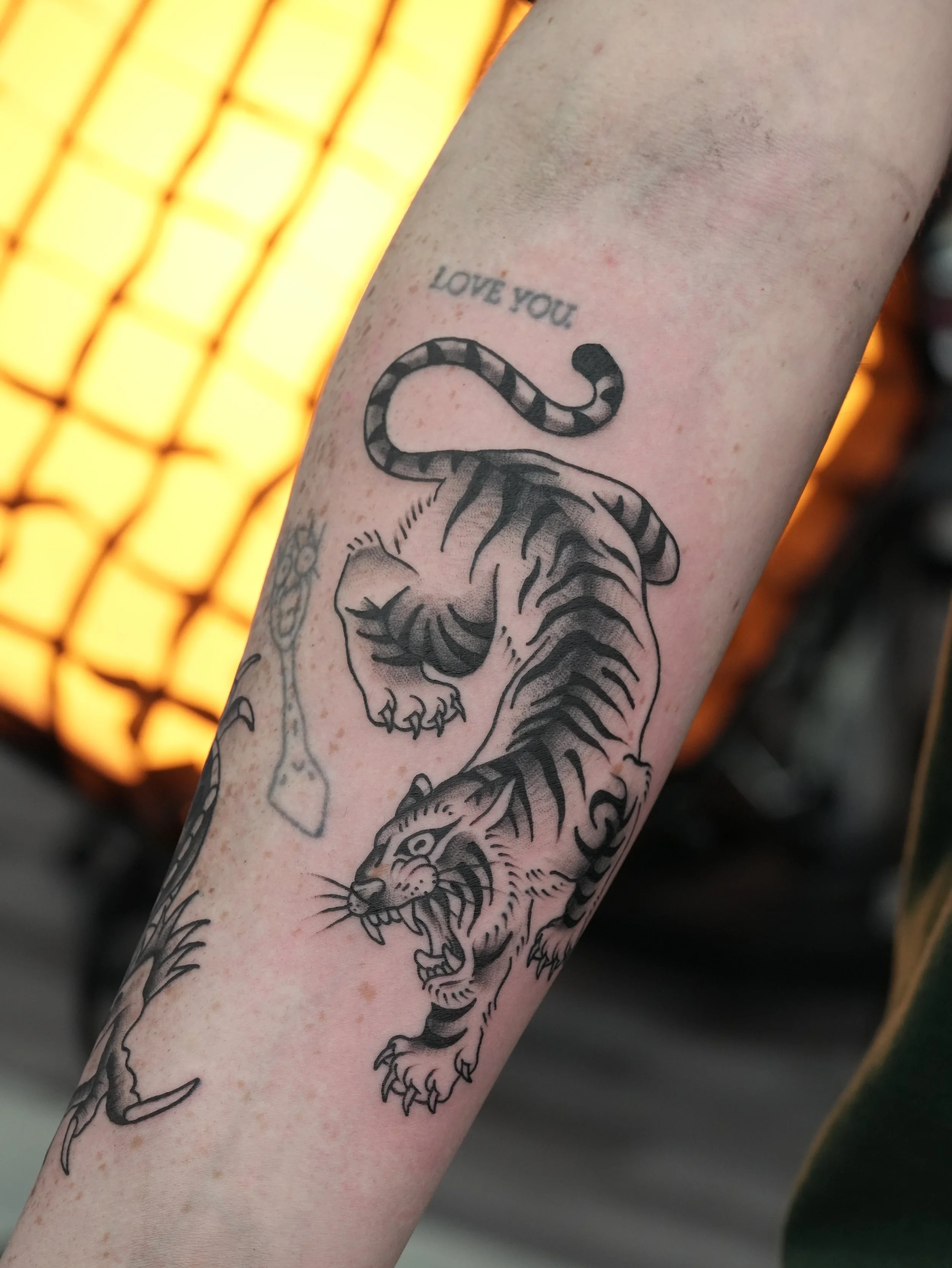 Traditional tiger tattoo in black and grey, featuring bold linework, dynamic movement, and classic tattoo styling. Custom tattoo by Yonathan Suarez, a traditional and illustrative tattoo artist in West Palm Beach, Florida.