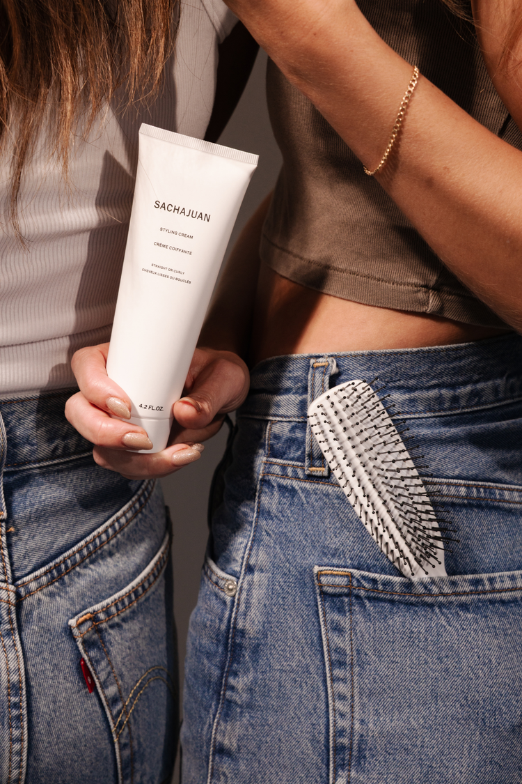 Styling cream and brush in a jeans pocket