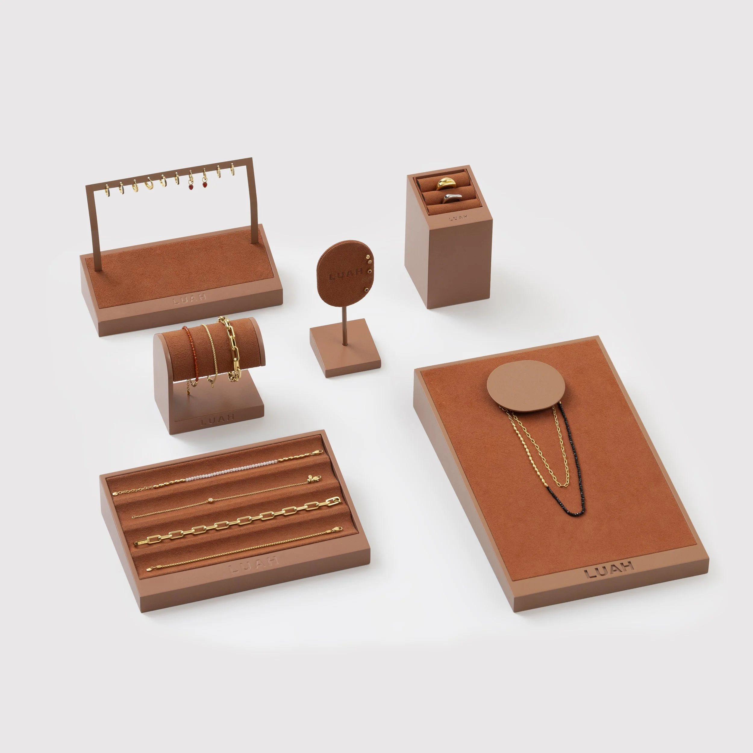 Set of jewelry including necklaces, rings, bracelets, and earrings displayed on brown stands and trays.