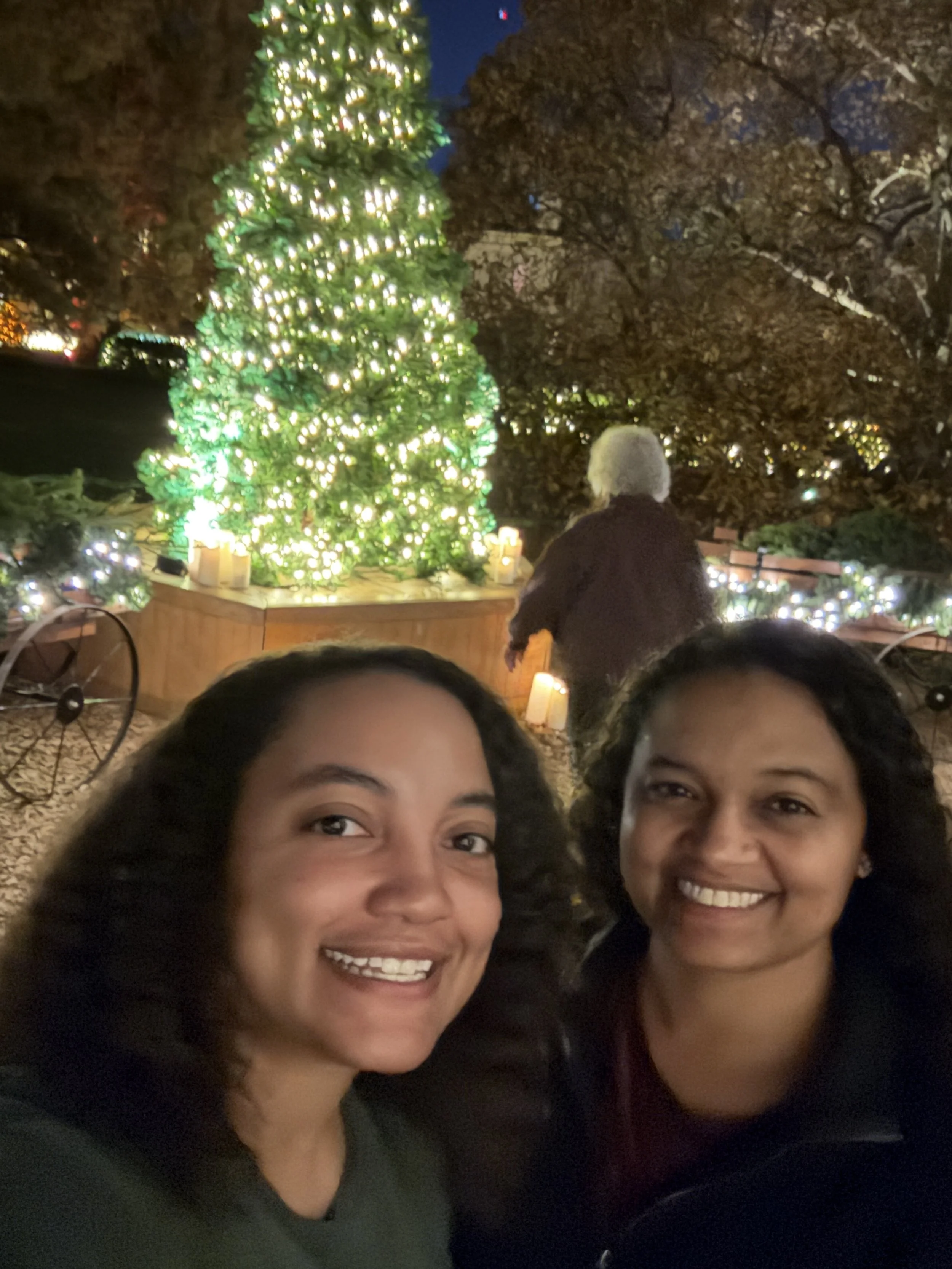Samantha and Lauren smiling in front of a Christmas tree