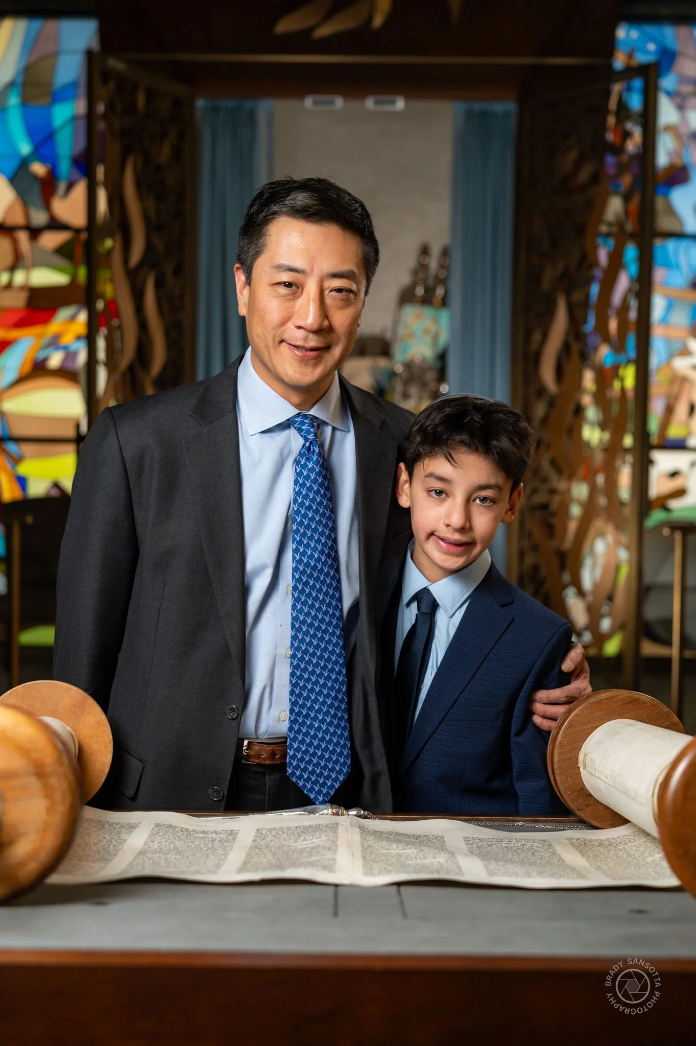 Father and son at the Torah. Professional Bar Mitzvah ceremony portraits at Temple Sinai in Tenafly.
