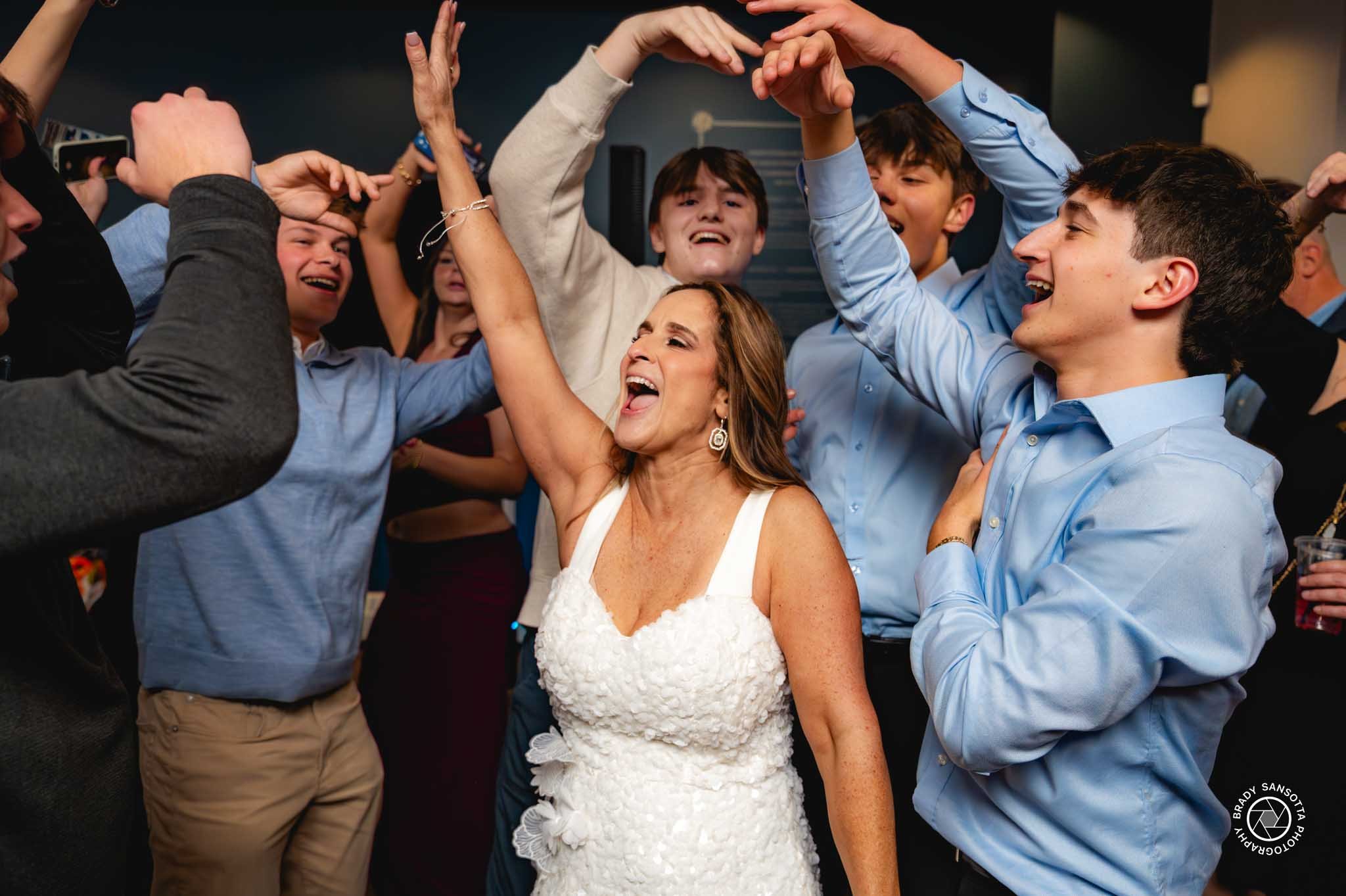 Candid shot of bride as she dances with guests at her wedding reception at the Rockland GAA