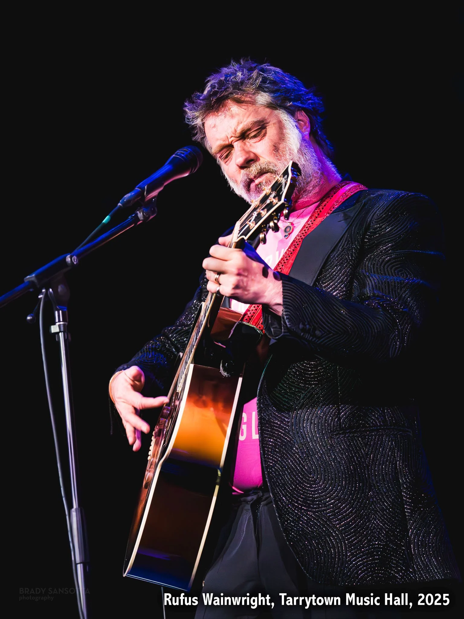 Rufus Wainwright playing guitar and singing during a live show at Tarrytown Music Hall in Westchester, New York.