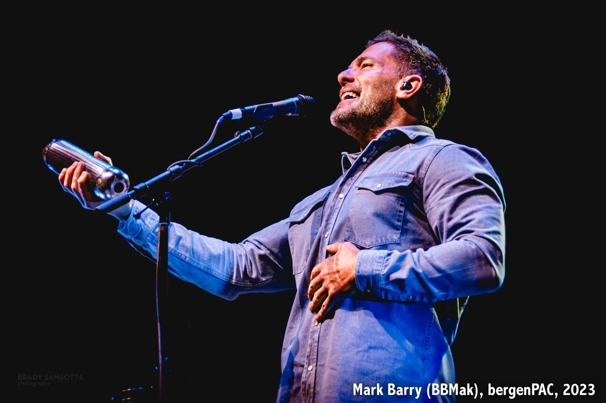 Portrait of Mark Barry of BBMak singing and shaking a guiro during the Pop 2000s Tour at BergenPAC in Englewood, NJ.
