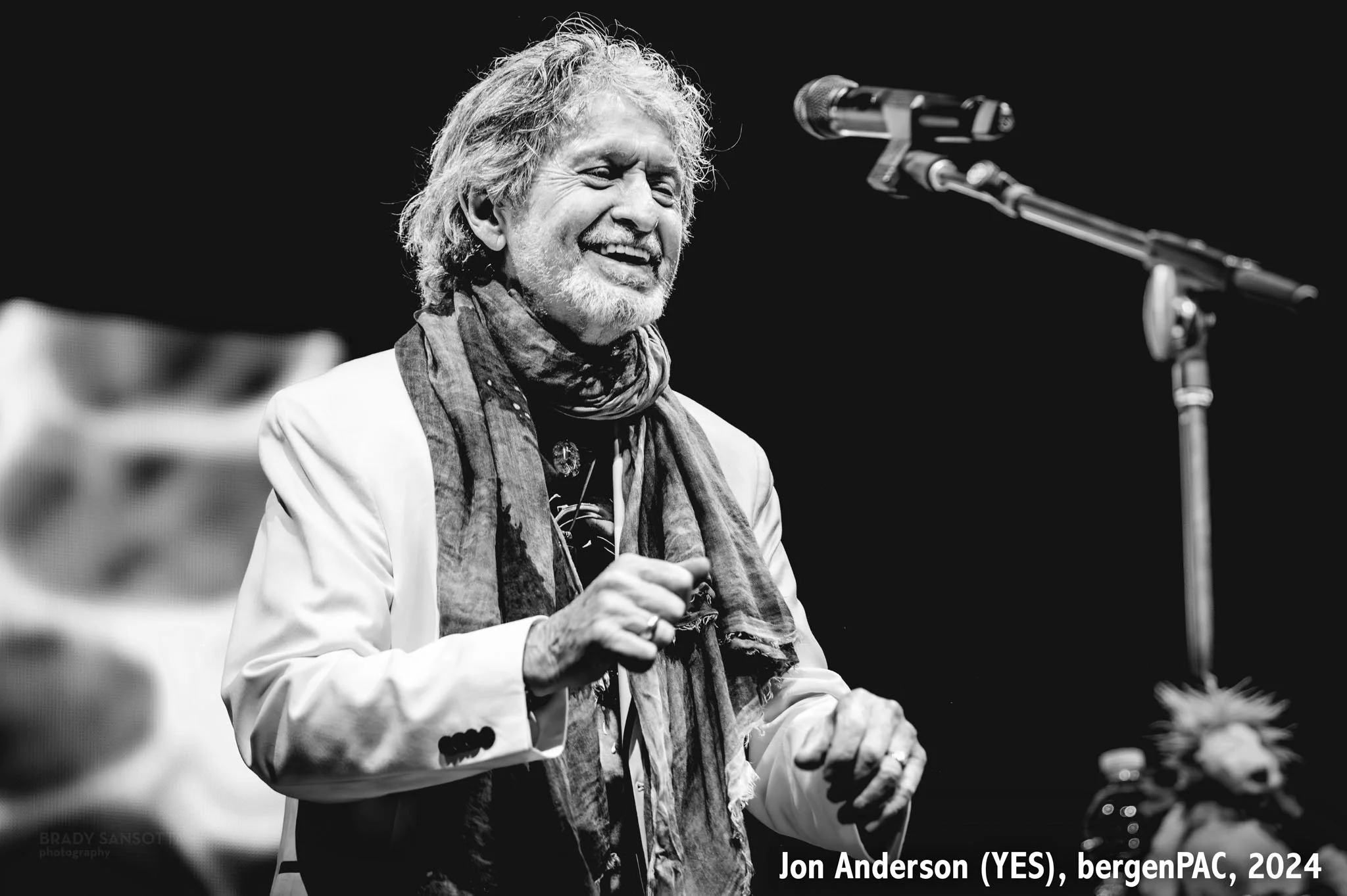 Black and white photo of Jon Anderson of Yes singing during a live progressive rock concert at BergenPAC in Englewood, NJ.