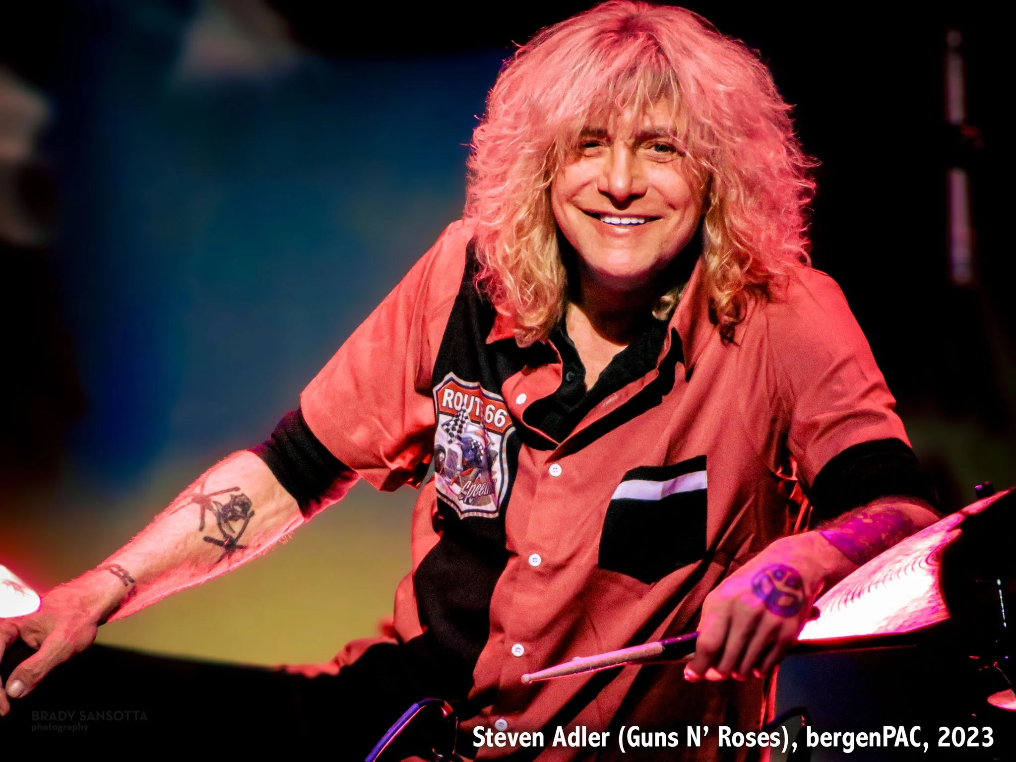 Steven Adler (formerly of Guns N' Roses) posing onstage on his drum set during a rock concert at BergenPAC.