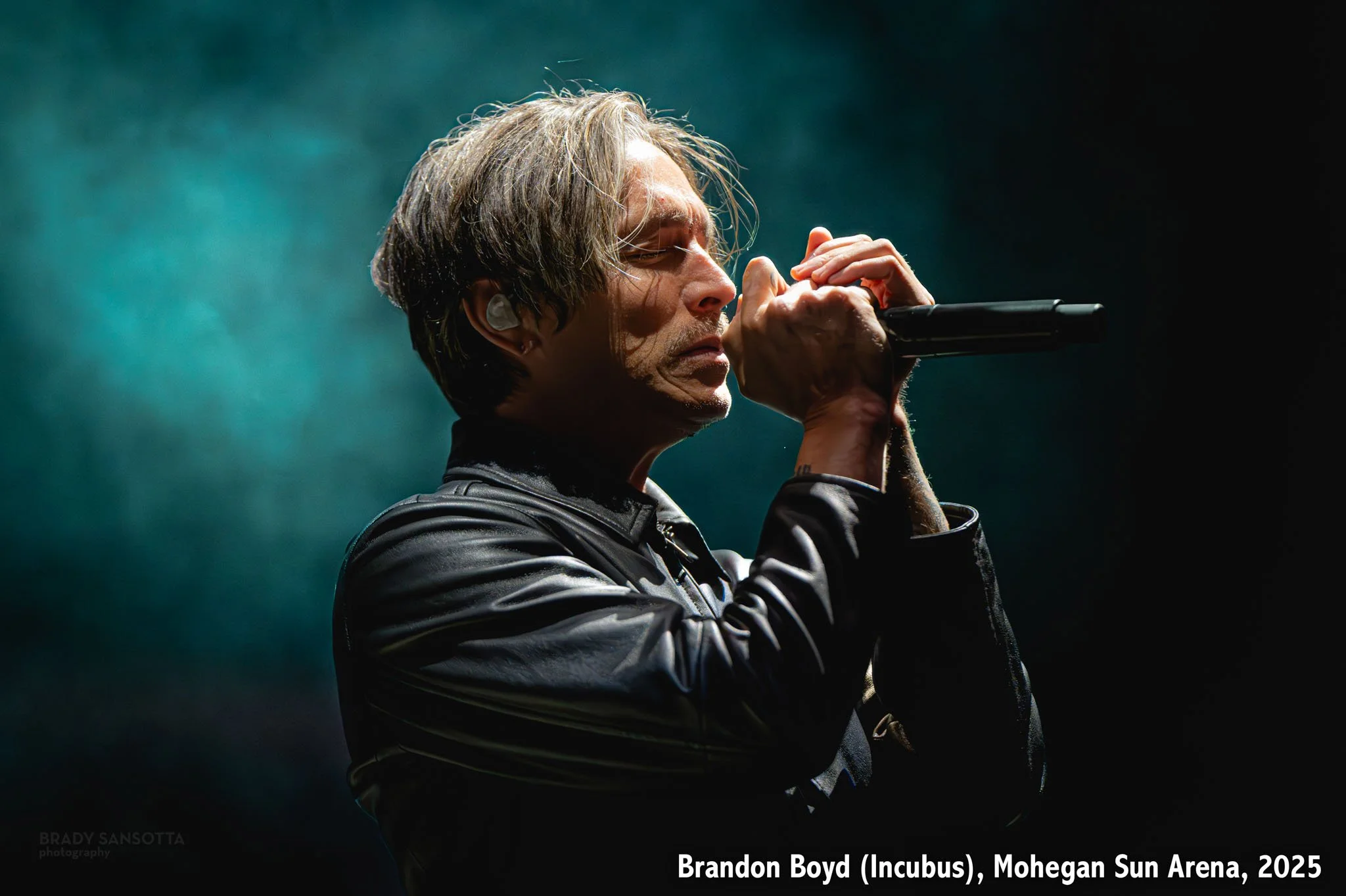 Dramatic photograph of Brandon Boyd of Incubus surrounded by stage fog at Mohegan Sun Arena in Uncasville, Connecticut.