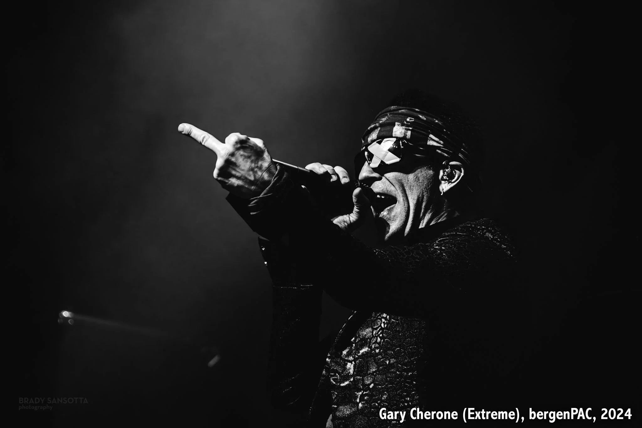 Black and white photo of Gary Cherone of Extreme singing and gesturing on stage at BergenPAC in Englewood, NJ.
