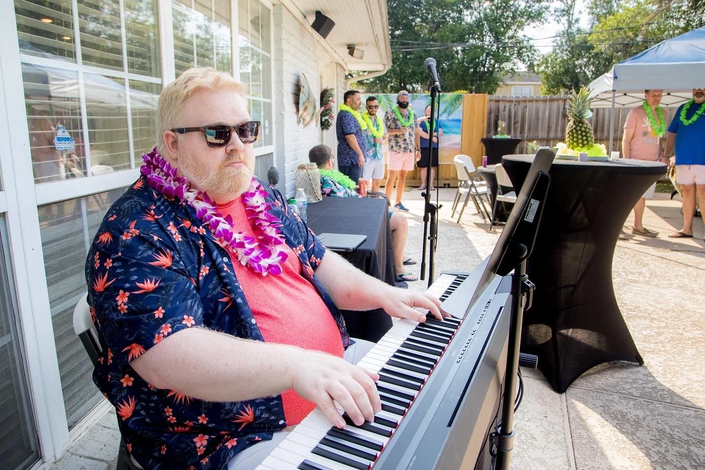 Guy Felder playing the piano at an outdoor party