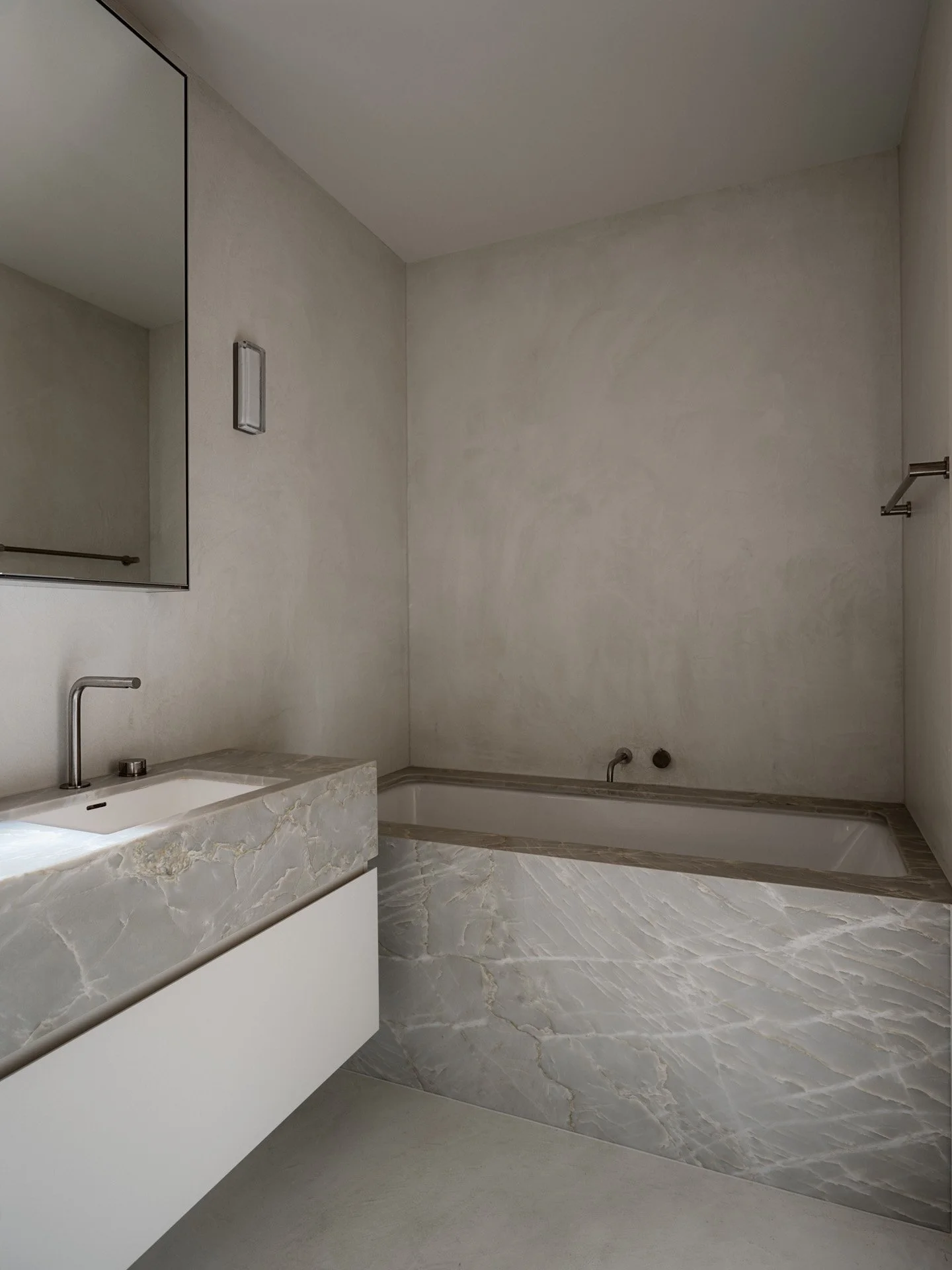 warm toned bathroom with microcement walls and statement stone joinery