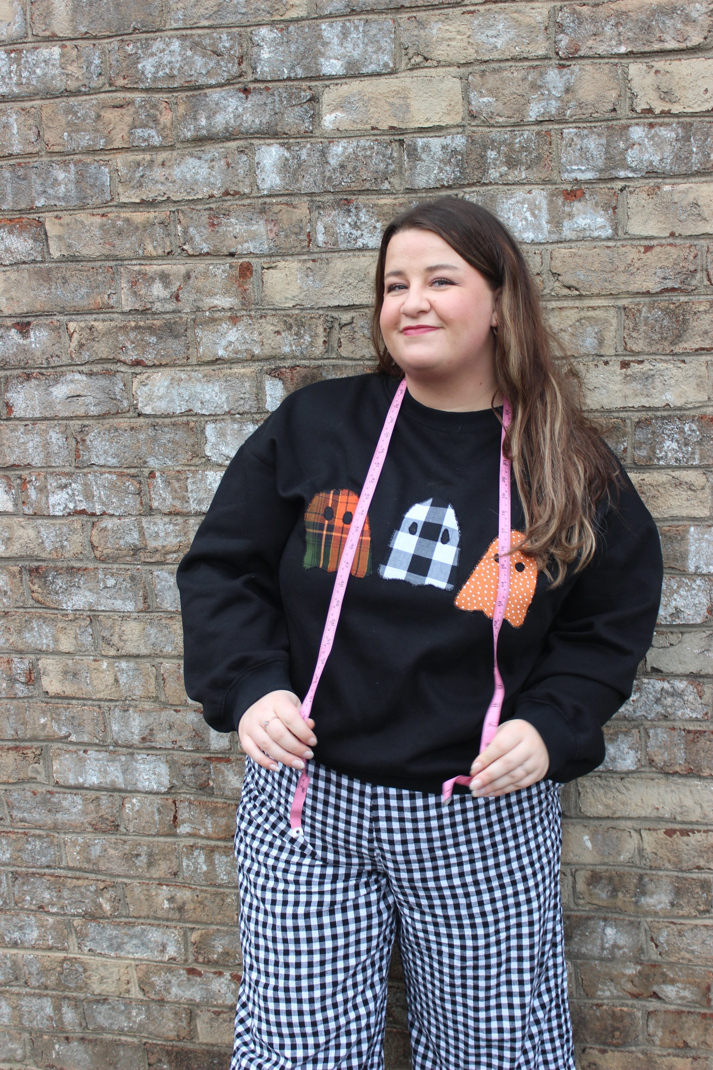 Angelina smiling with a tape measure draped around her neck