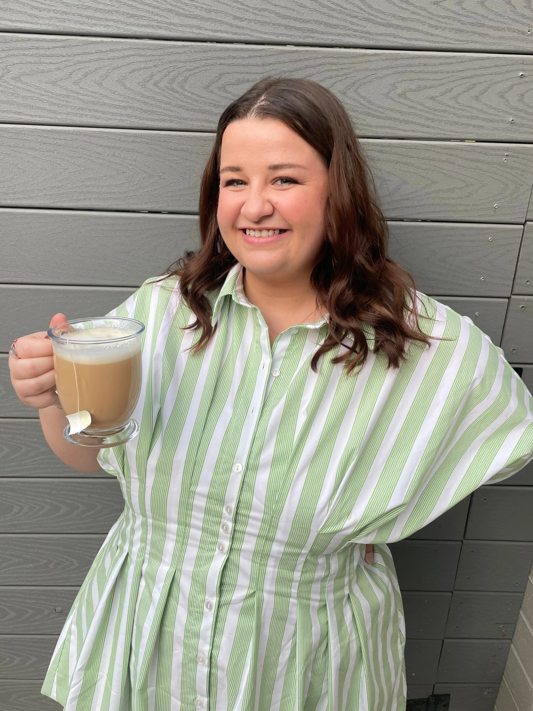 Angelina, founder of Bergamot Sunshine Co., smiling and holding a coffee cup.