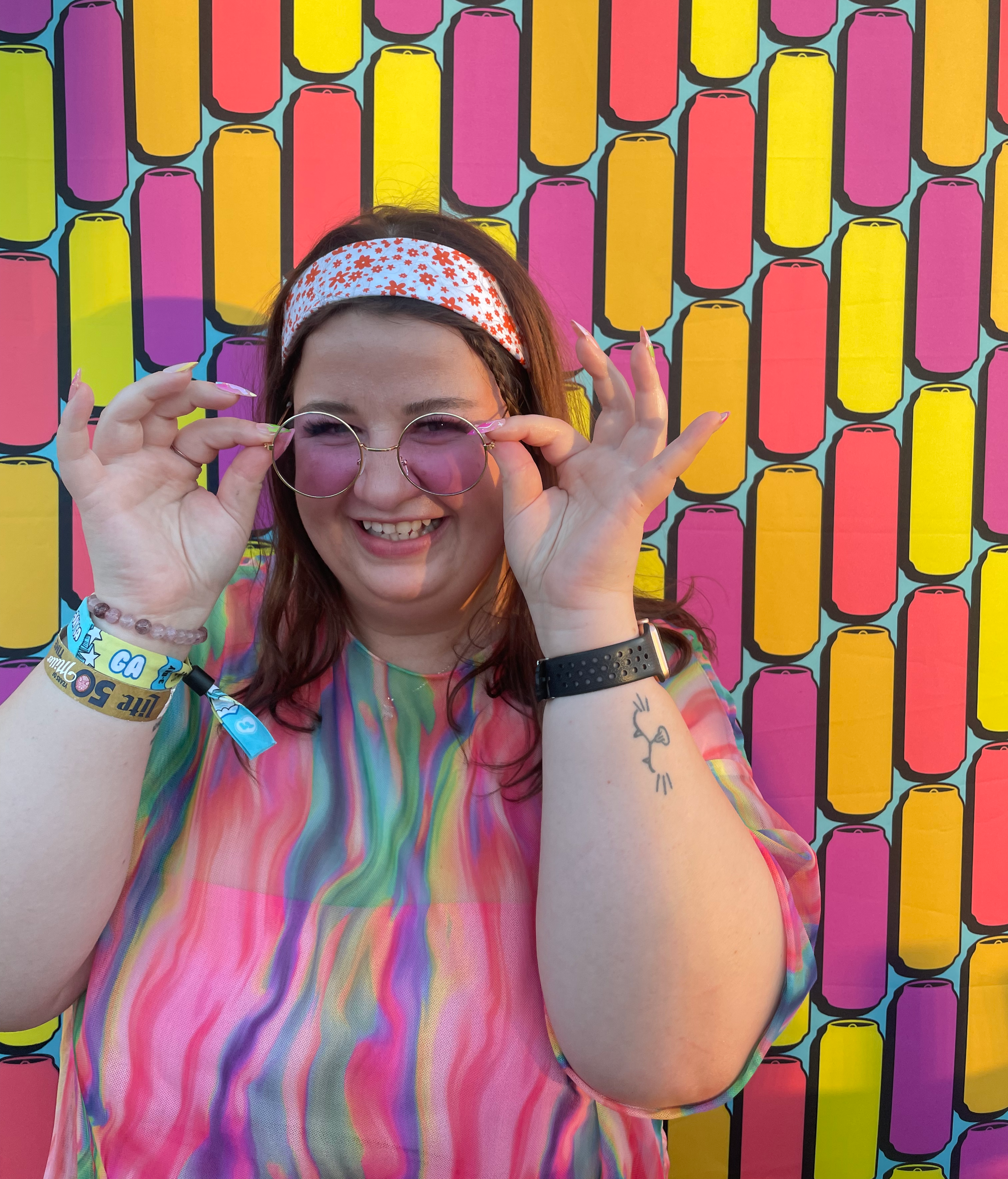 Angelina models her own work against a colorful background.