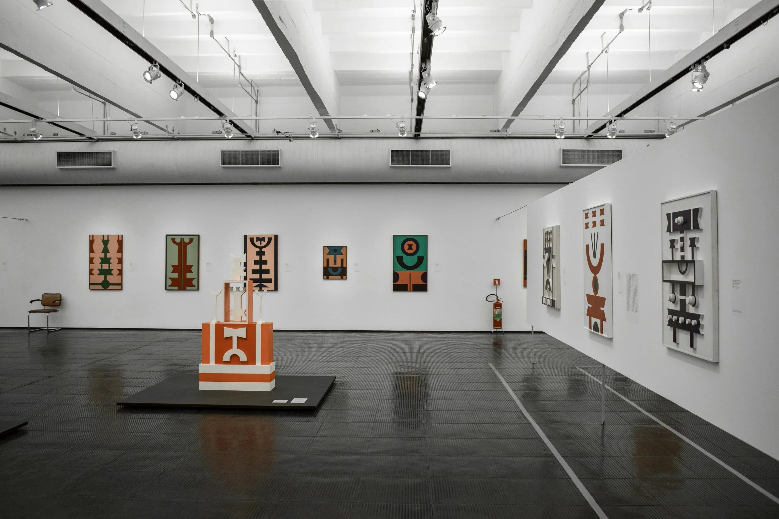 Contemporary art gallery displaying abstract artworks in a large open exhibition space