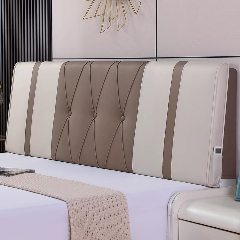 Modern bedroom with a decorated bed featuring a padded headboard with beige and white sections and decorative lines. A beige knit blanket is draped over the white bed sheet.